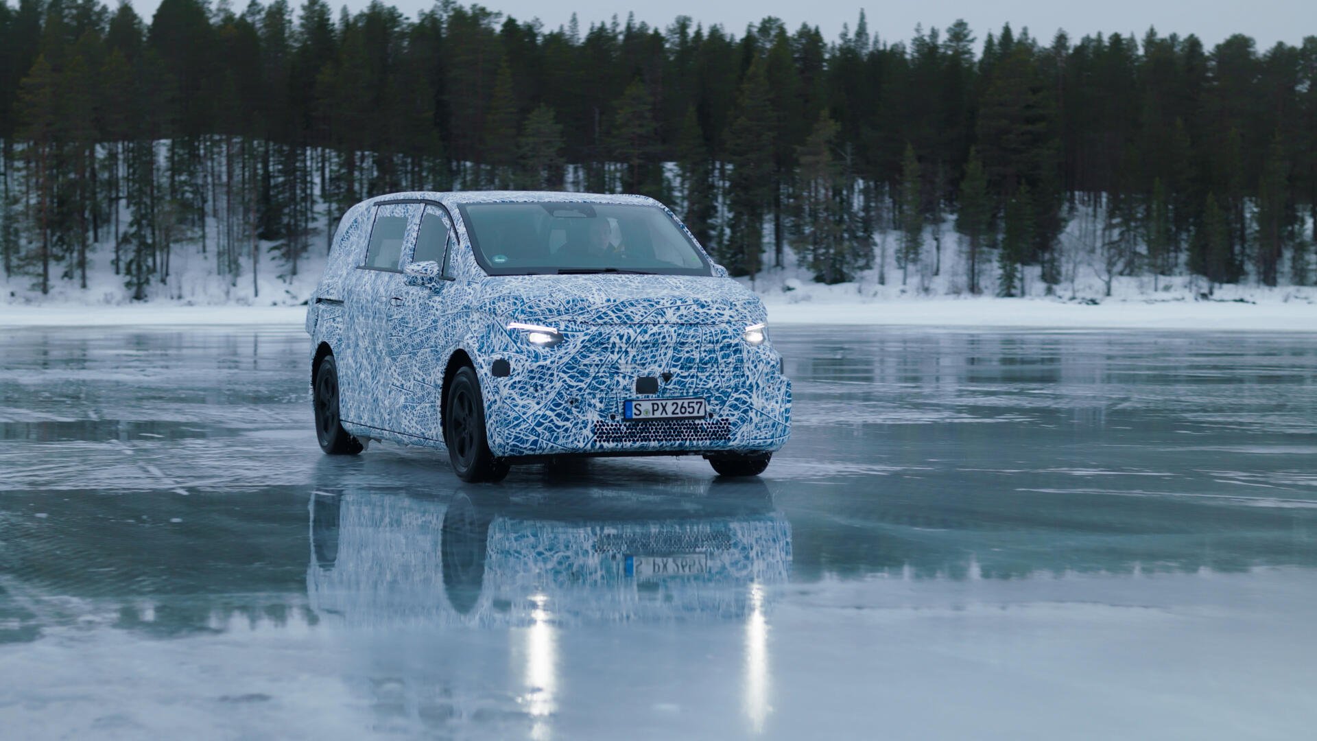 A Mercedes-Benz MPV is seen on a frozen lake, showcasing a camouflaged design against a backdrop of snowy trees. This striking image serves as a 4K Ultra HD desktop wallpaper.
