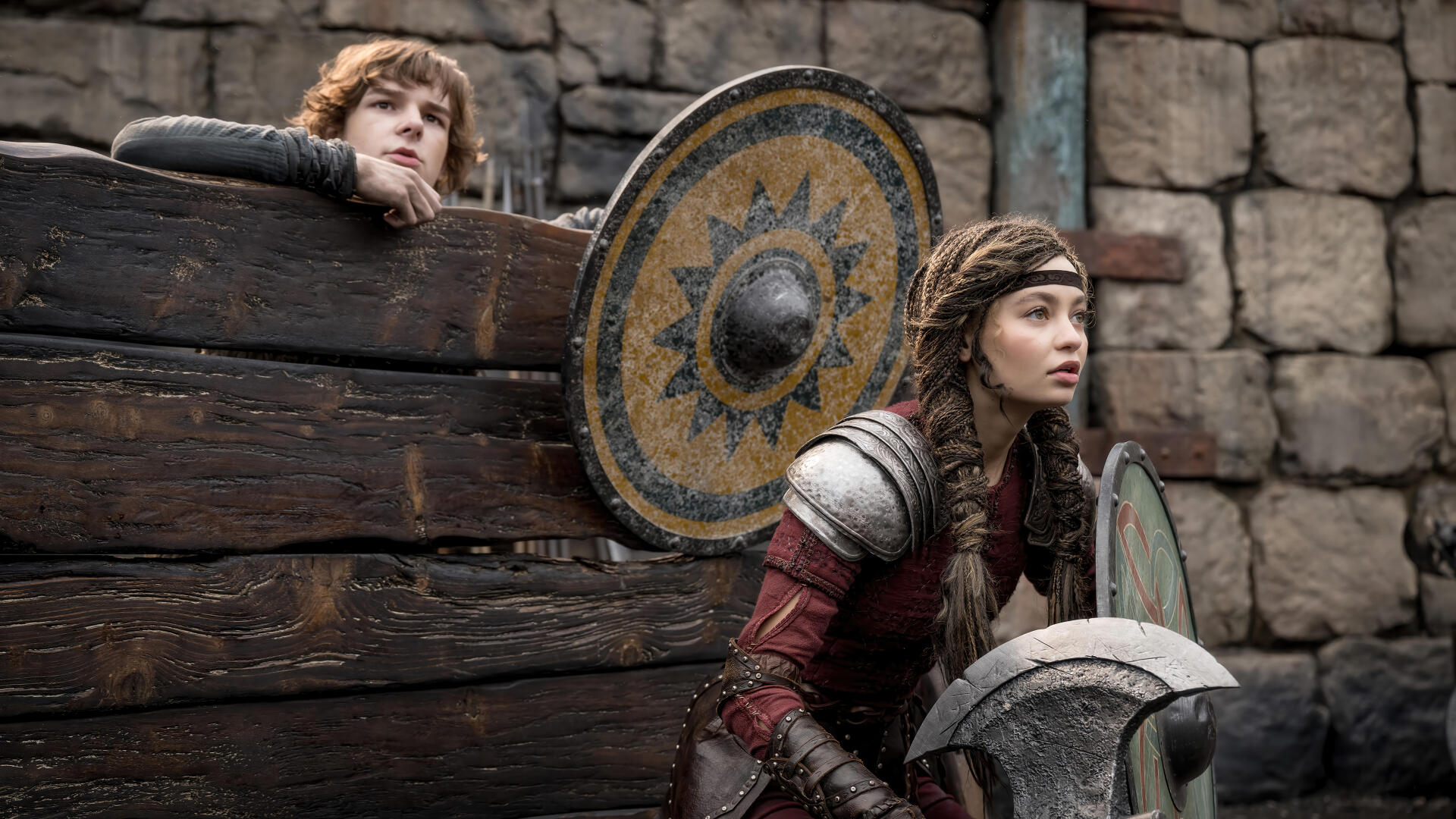 Hiccup and Astrid from How to Train Your Dragon (2025) are featured in this 4K Ultra HD wallpaper, showcasing their adventurous spirit against a stone backdrop.