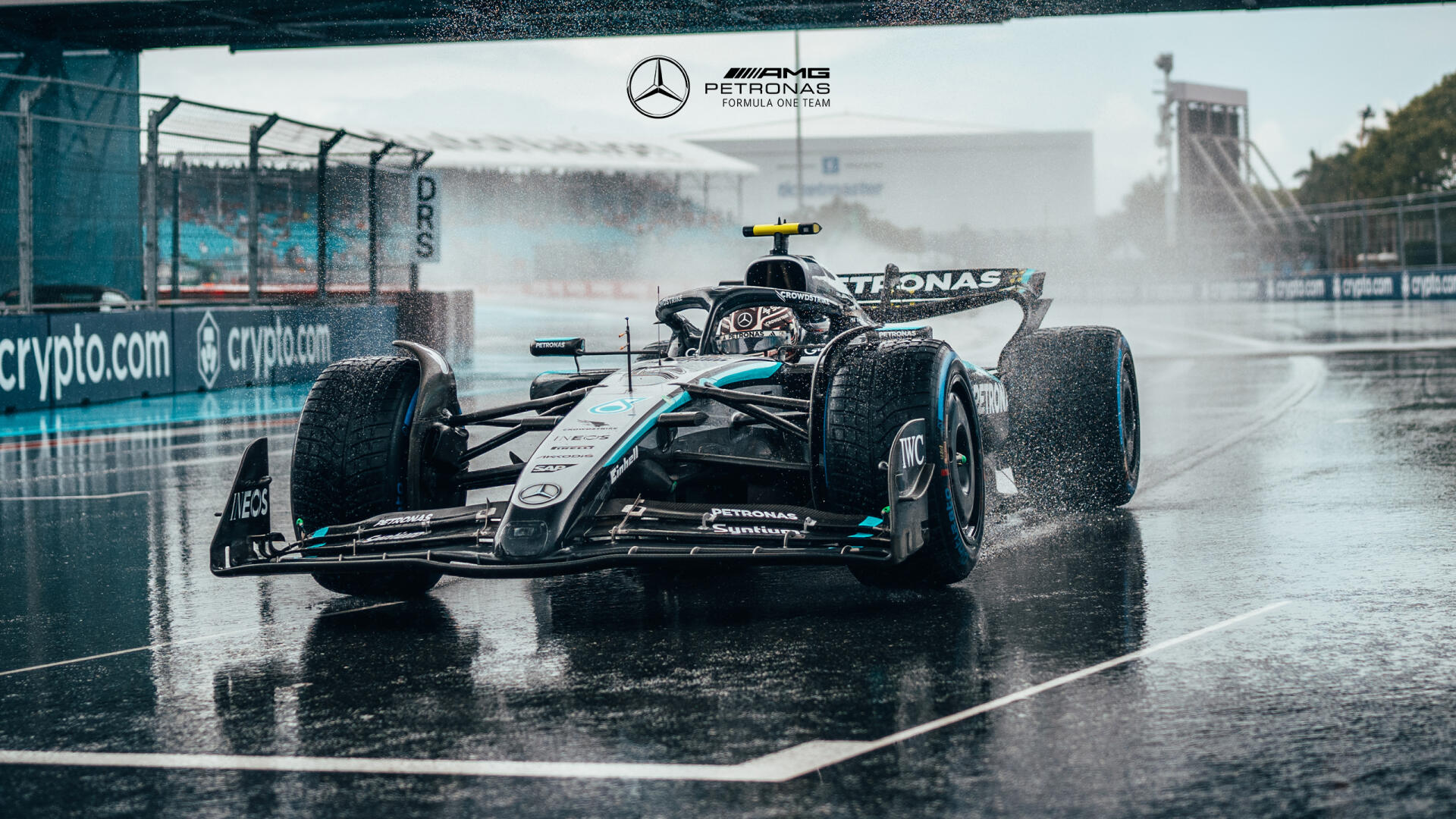 F1 Mercedes AMG Petronas car races on a wet track, captured in high-definition for a dynamic PC desktop wallpaper and background.