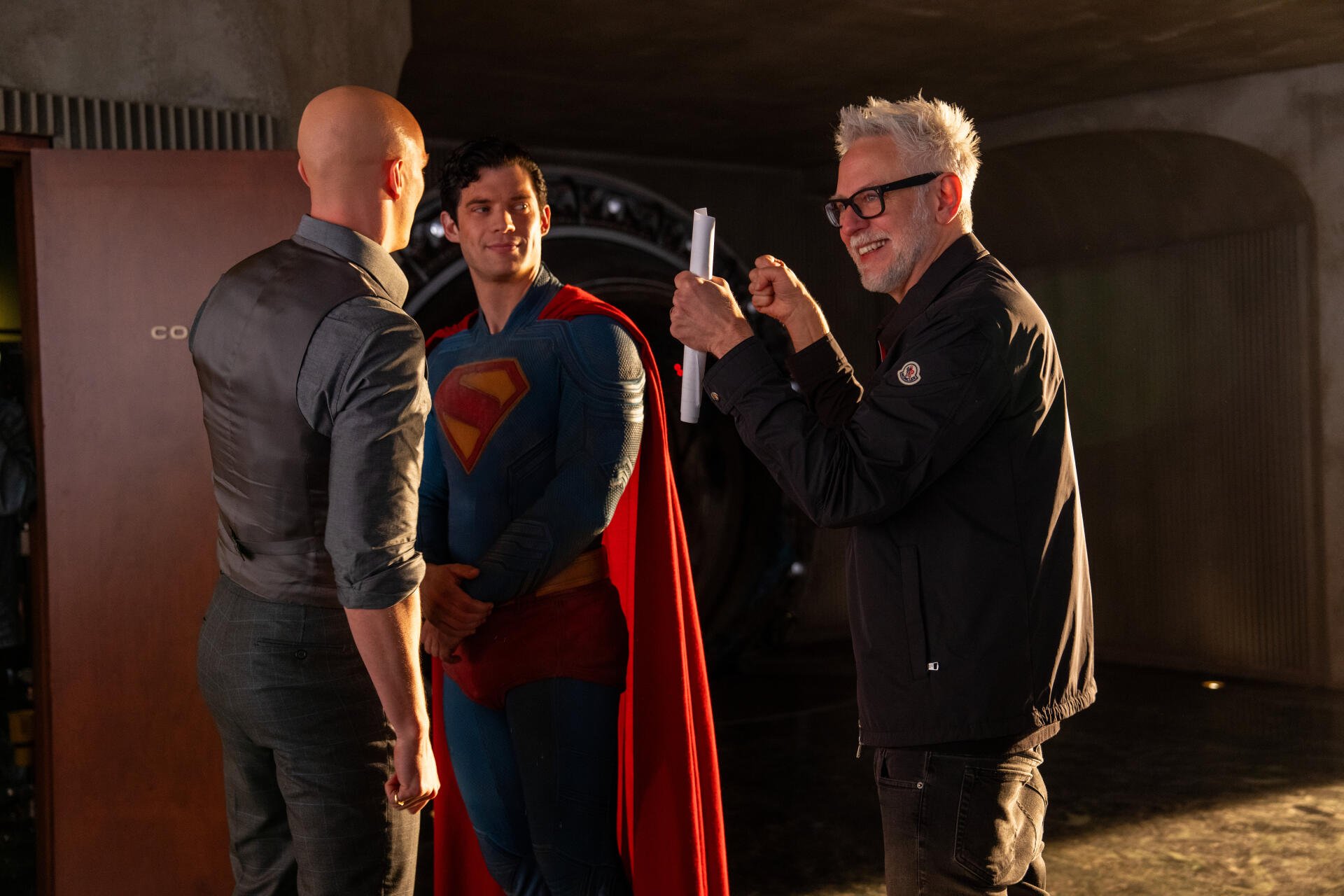 Behind-the-scenes moment from Superman (2025) featuring a director capturing a scene with Superman and another character, presented in 8K Ultra HD PC desktop wallpaper quality.