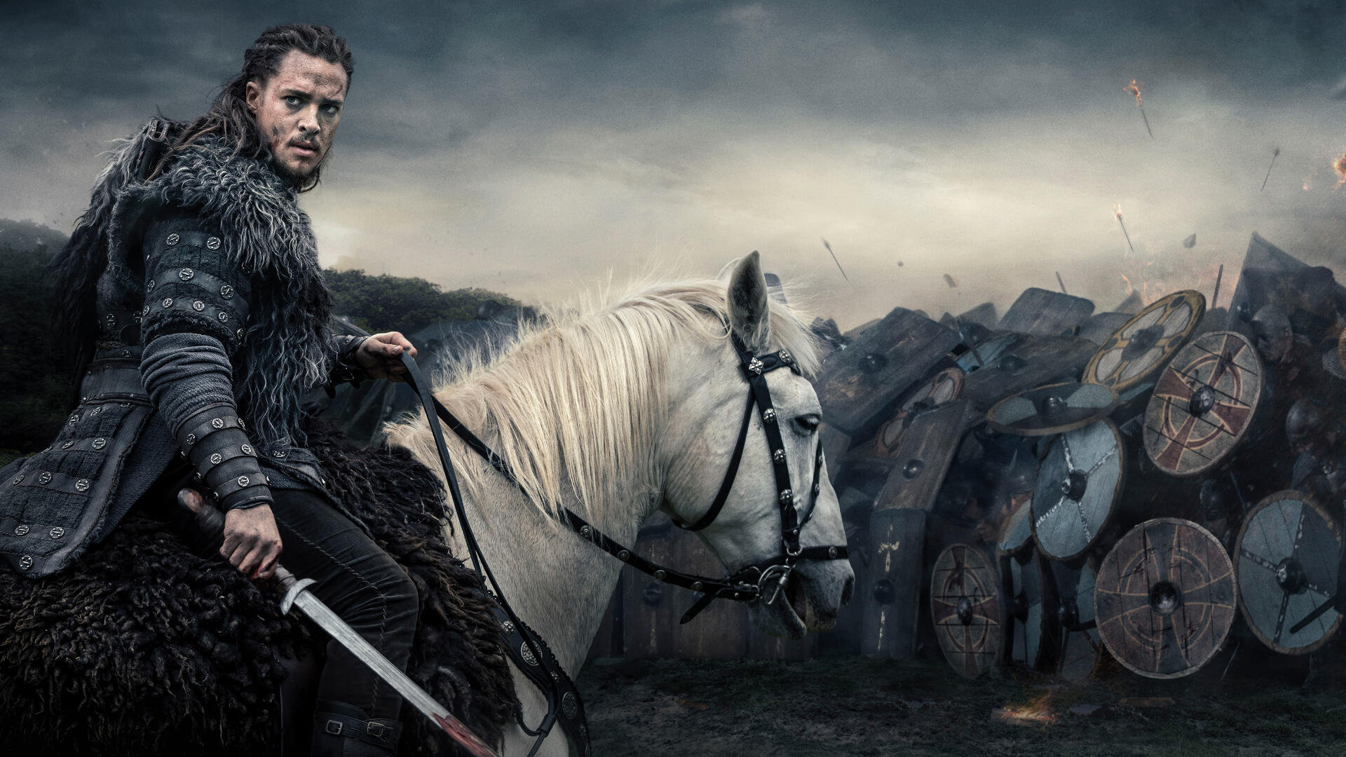 A warrior from The Last Kingdom in dark armor rides a white horse against a battlefield backdrop, featured in a 4K Ultra HD PC desktop wallpaper and background.