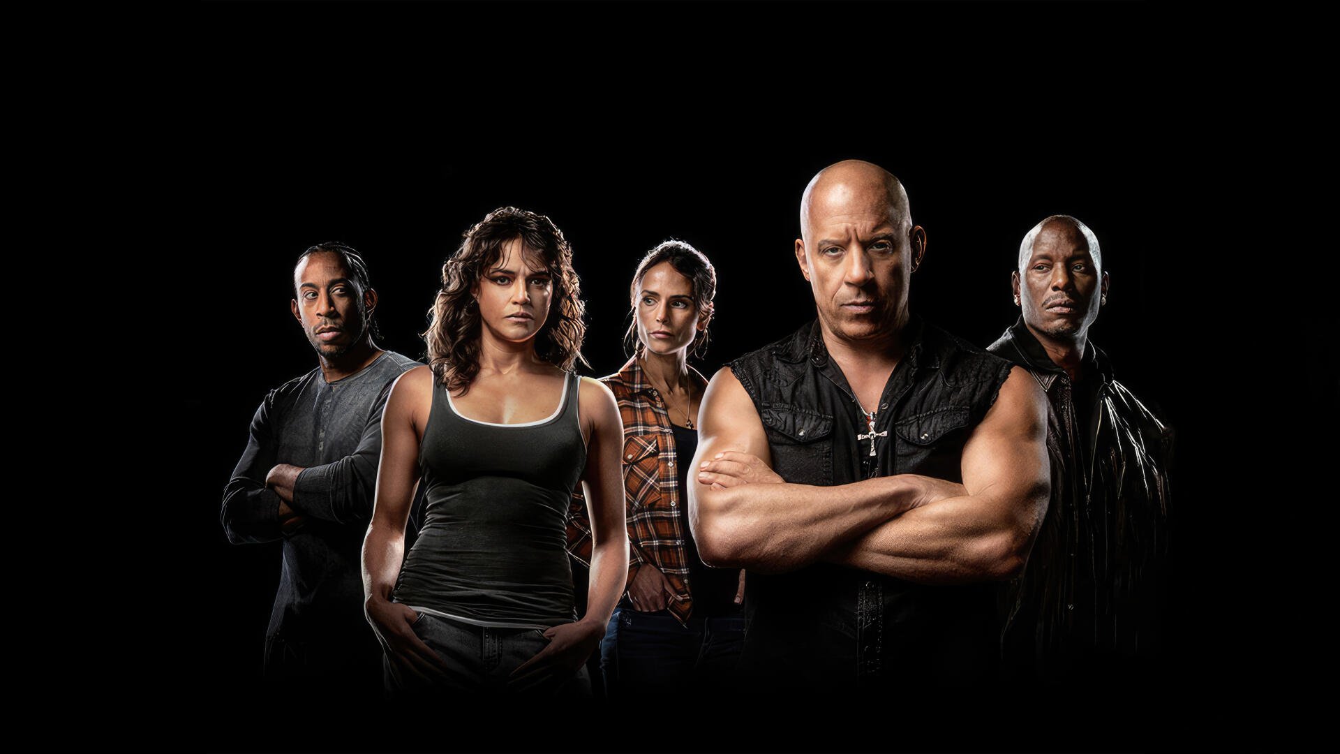 Five tense, muscular Fast X characters stand in a row against a black background, arms folded and serious faces — 4K Ultra HD PC Desktop Wallpaper and Background.