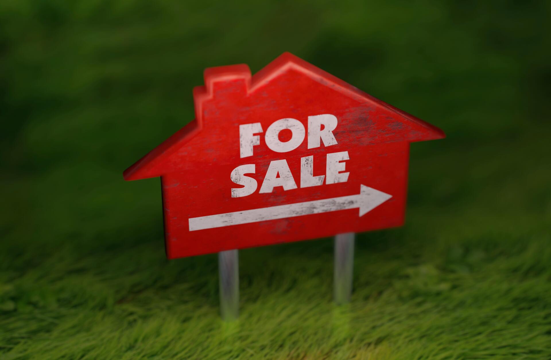 HD PC desktop wallpaper showing a red house-shaped real estate For Sale sign with an arrow planted in green grass, advertisement-style background.