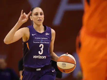 Diana Taurasi of the Phoenix Mercury gestures confidently while holding a basketball, showcasing her dynamic presence in the WNBA. A vibrant HD desktop wallpaper.