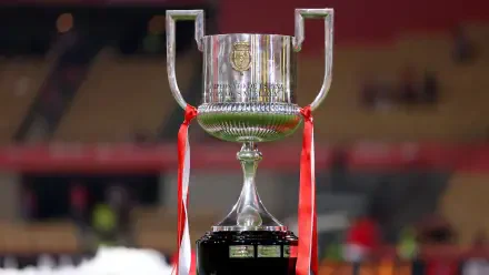 A close-up of the Copa del Rey trophy, featuring silver details and red ribbons, set against a blurred stadium background. This HD image serves as a dynamic soccer-themed desktop wallpaper.