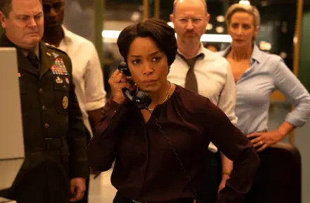 A dramatic scene from Mission: Impossible - The Final Reckoning, featuring a woman on the phone in a tense situation, surrounded by focused characters in a sophisticated command center.