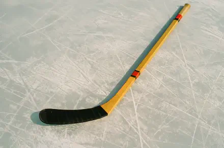 4K Ultra HD desktop wallpaper featuring a yellow and black hockey stick resting on a textured ice surface.