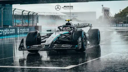 F1 Mercedes AMG Petronas car races on a wet track, captured in high-definition for a dynamic PC desktop wallpaper and background.