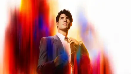 Superman (2025) in a suit, adjusting his tie amid vivid red, blue and gold light streaks — 8K Ultra HD PC desktop wallpaper background.
