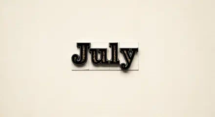 4K Ultra HD PC desktop wallpaper featuring the word July in black letterpress type on a light beige background.