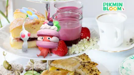 HD PC desktop wallpaper featuring a Pikmin character styled as a dessert among colorful cakes, fruits, and drinks, with a Pikmin Bloom logo in the corner.