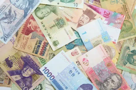 HD PC desktop wallpaper showing scattered international banknotes and currency — colorful close-up of money from multiple countries.