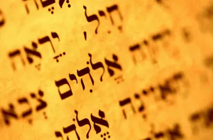 Close-up of Hebrew Torah script on aged parchment in warm golden tones — Jewish Bible religious text presented as an HD PC desktop wallpaper background.
