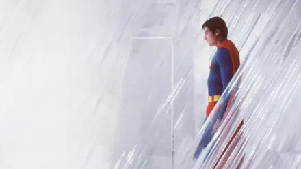 Superman (1978) in blue-and-red suit, side profile beside a crystalline wall; HD PC desktop wallpaper and background with soft light and minimalist composition.