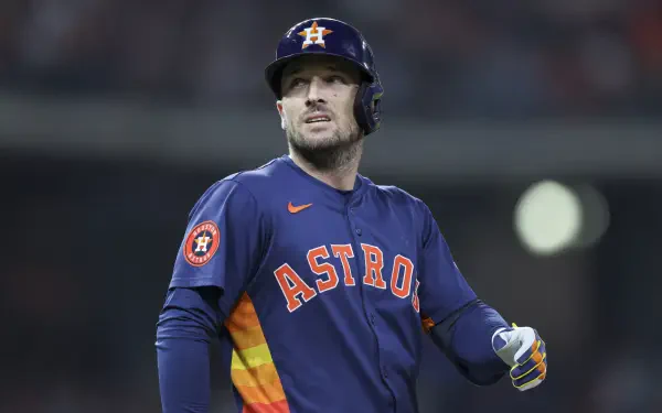 Alex Bregman of the Houston Astros, adorned in his team's orange and navy uniform, stands confidently on the field during an MLB game, showcasing the spirit of baseball.