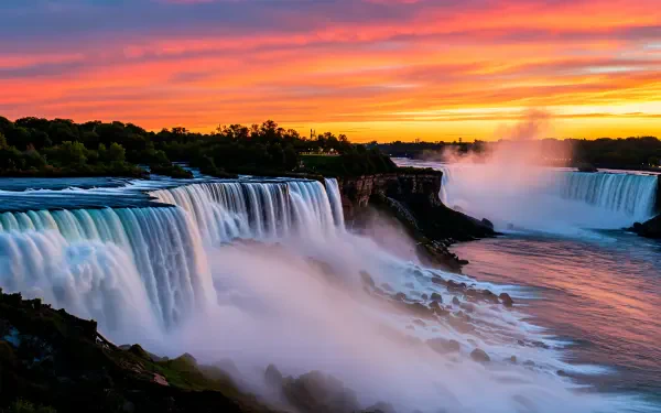 A stunning 4K Ultra HD image of Niagara Falls at sunset, showcasing cascading water and vibrant orange and purple hues in the sky, capturing the beauty of this natural wonder.