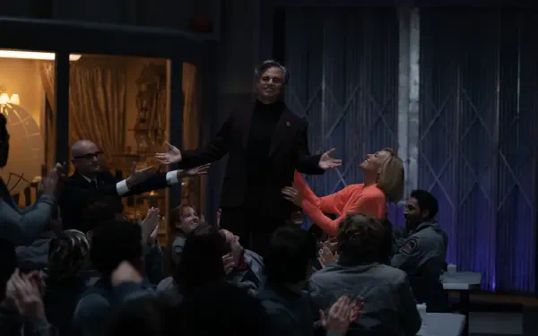 A scene from the movie Mickey 17 (2025) featuring Mark Ruffalo, where he stands confidently amidst an engaged audience, creating a dynamic atmosphere. 4K Ultra HD wallpaper.