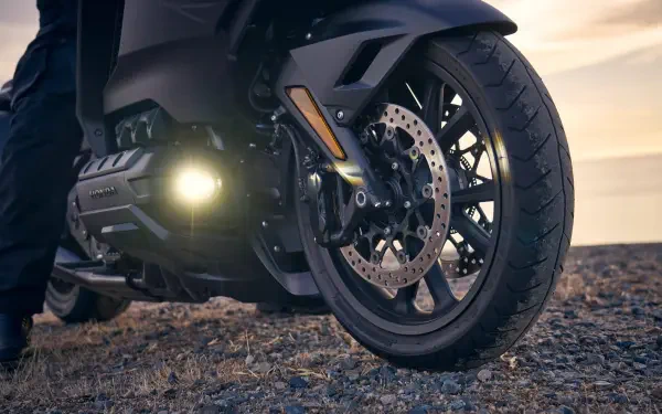 Close-up of the front wheel and engine of a 25YM Honda GL 1800 Gold Wing motorcycle, featured in an HD PC desktop wallpaper background.