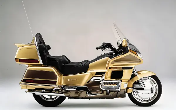 A sleek 25YM Honda GL 1800 Gold Wing motorcycle in stunning gold finish, showcased against a neutral background, designed as a 4K Ultra HD PC desktop wallpaper.