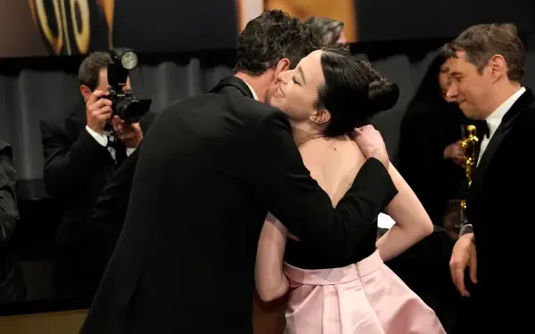 Mikey Madison shares a joyful hug at the Academy Awards, captured in this vibrant 4K Ultra HD desktop wallpaper showcasing a celebratory moment.