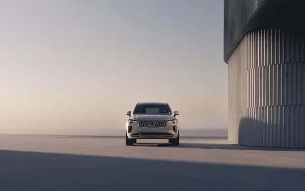 A sleek Volvo XC90 Facelift stands prominently in a minimalist setting, showcasing its modern design and elegance against a soft, light-filled backdrop.