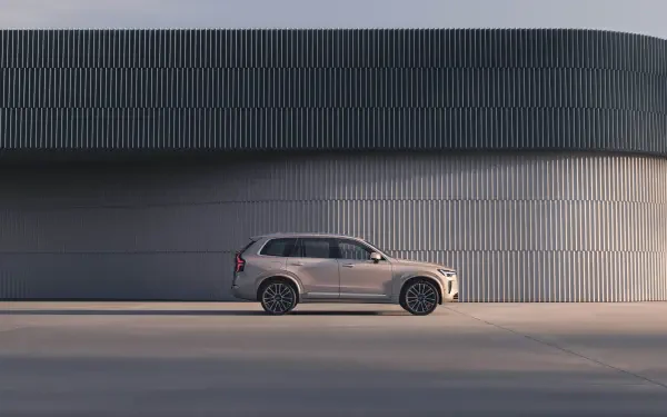 A sleek Volvo XC90 Facelift parked alongside a modern architectural structure, showcased in a 4K Ultra HD resolution for a striking desktop wallpaper.