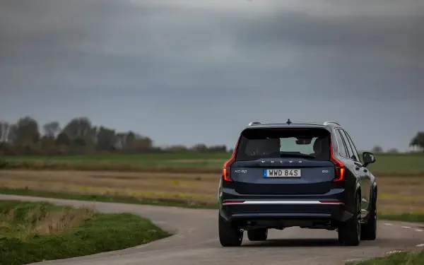 A sleek Volvo XC90 Facelift drives along a winding road, set against an expansive landscape, captured in stunning 4K Ultra HD for a captivating desktop wallpaper.