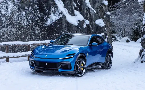 A stunning blue Ferrari Purosangue parked in a snowy landscape, showcasing its sleek design. This image serves as an 8K Ultra HD PC desktop wallpaper.