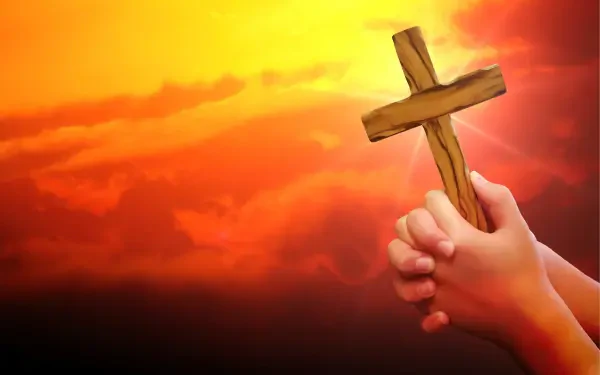 HD desktop wallpaper featuring hands holding a wooden cross against a vibrant orange sky, symbolizing prayer and religious faith.
