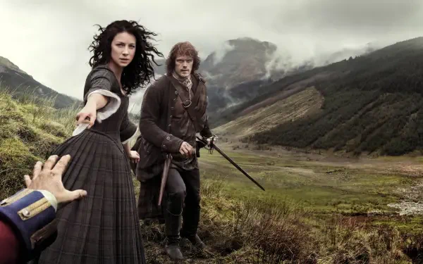 4K Ultra HD Outlander wallpaper featuring two characters in period clothing on a misty Scottish hillside, with one reaching out and the other holding a sword.