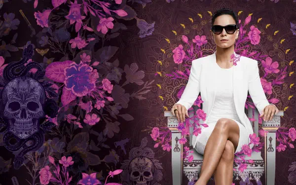 HD PC desktop wallpaper featuring a confident woman in white seated on a throne, surrounded by dark purple floral and skull designs, themed around Queen of the South.