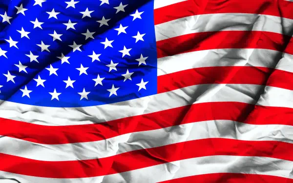 Crumpled silk United States flag with stars and stripes, vibrant HD 4th of July desktop wallpaper.