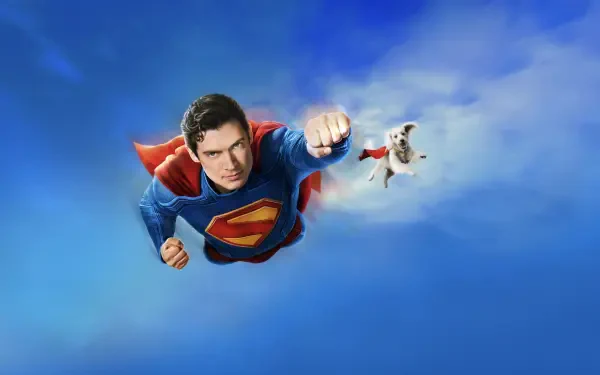 Superman (2025) flying toward the viewer with cape billowing against a vivid blue sky — 4K Ultra HD PC desktop wallpaper and background.