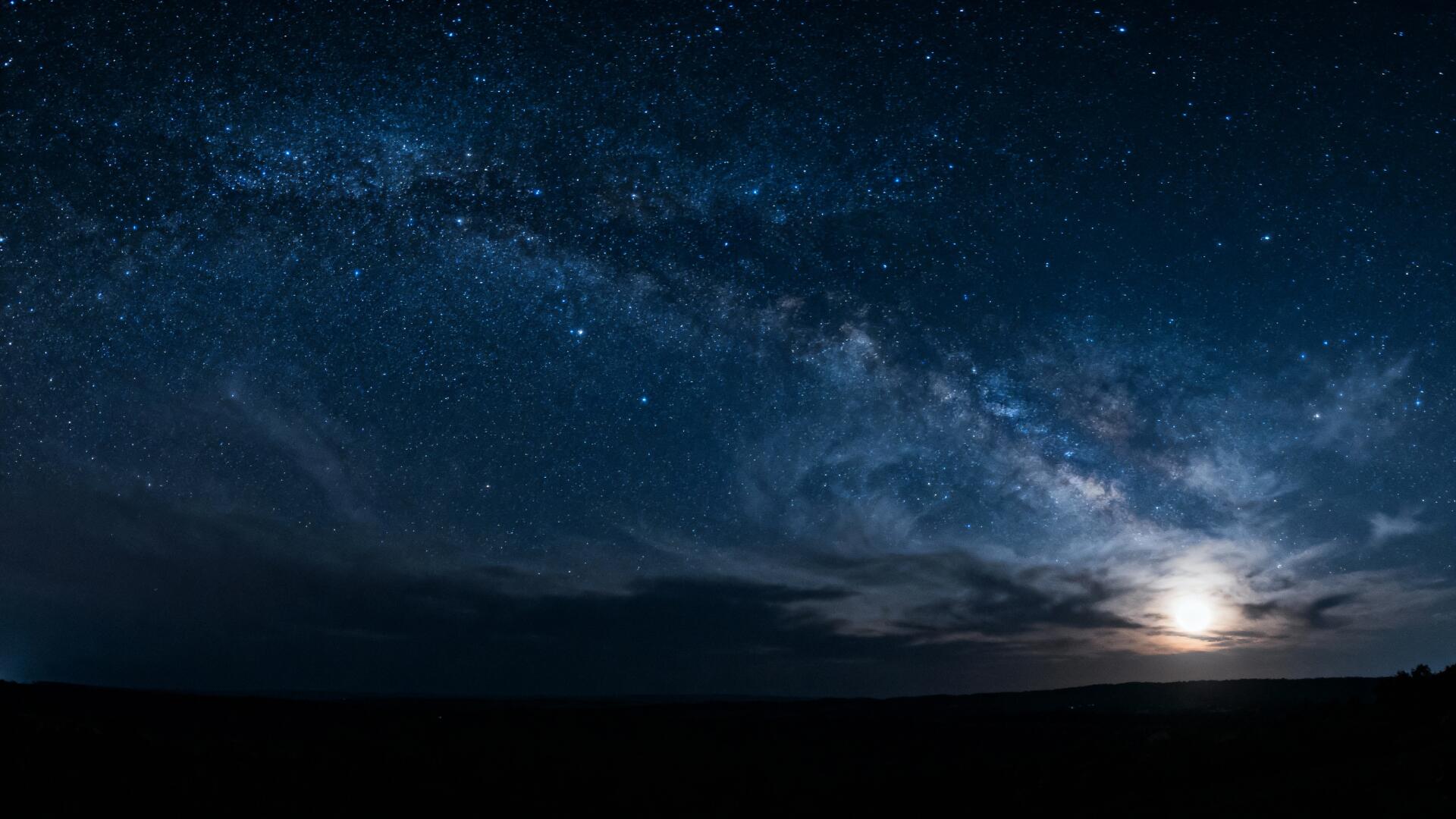 Starry night sky with the Milky Way and a glowing moon over a dark horizon — 4K Ultra HD PC desktop wallpaper and background