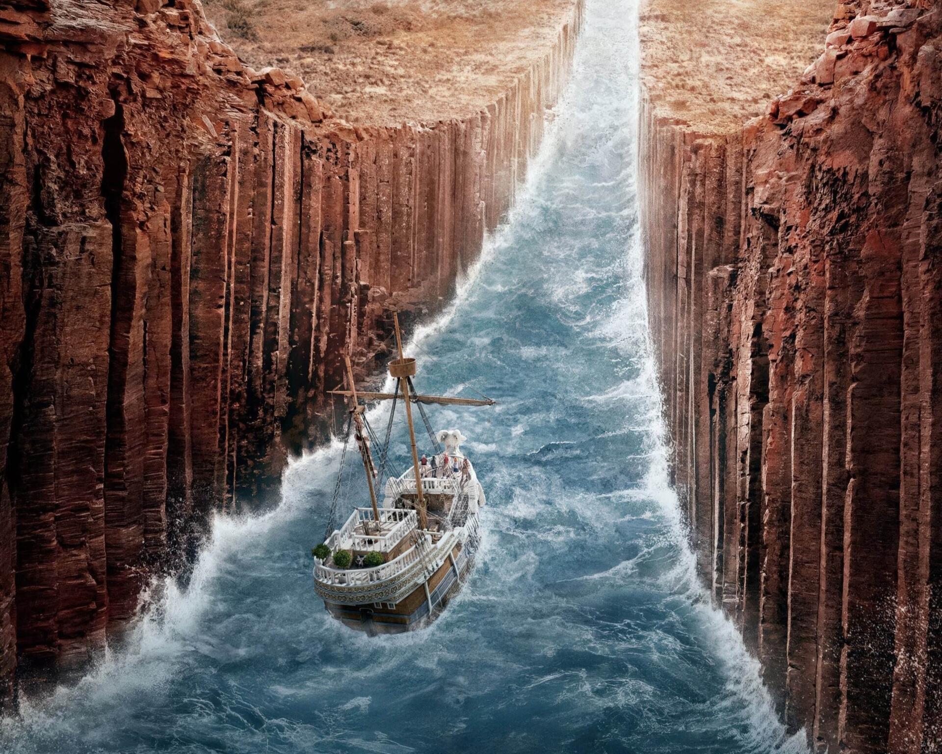 2K Quad HD PC desktop wallpaper and background — TV show One Piece (Live Action): a ship plows turbulent blue waters through a narrow canyon of towering red cliffs, sunlight breaking above.