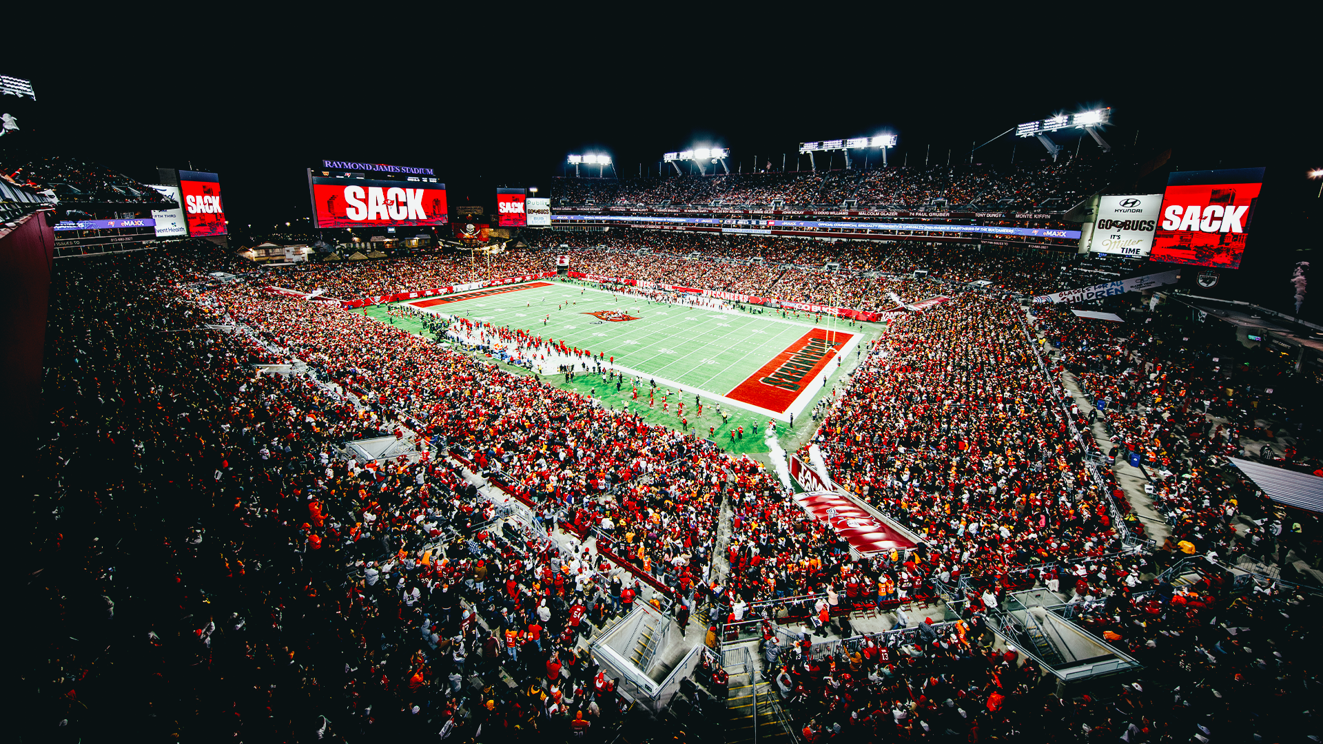 HD PC desktop wallpaper/background: panoramic night view of Tampa Bay Buccaneers stadium, packed stands and illuminated field.