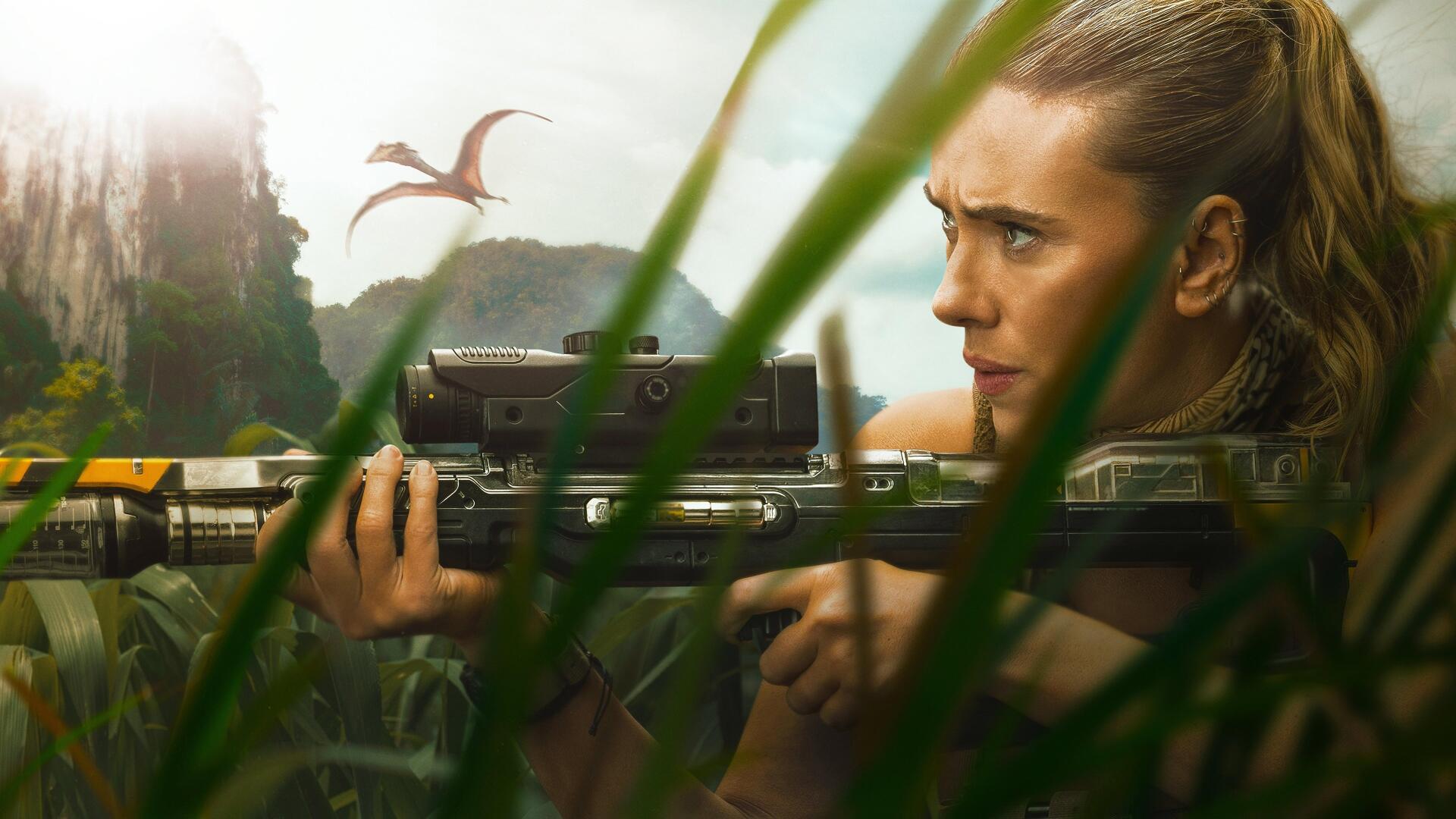 Jurassic World Rebirth 4K Ultra HD PC desktop wallpaper: close-up of a focused woman aiming a high-tech rifle through jungle foliage as pterosaurs circle a volcanic island.