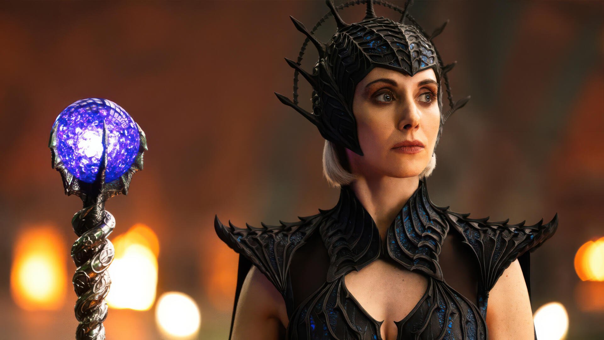 4K Ultra HD PC desktop wallpaper: armored wizard from Masters of the Universe (2026) wearing a horned crown and holding a glowing crystal staff, featuring an actress in the role.