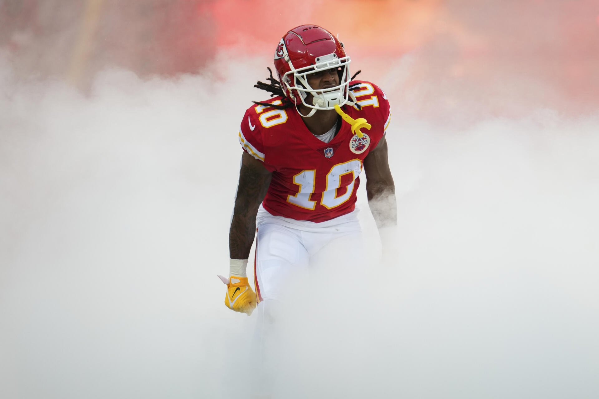 Kansas City Chiefs player in red No. 10 jersey emerging through thick smoke — 2K Quad HD PC desktop wallpaper background.