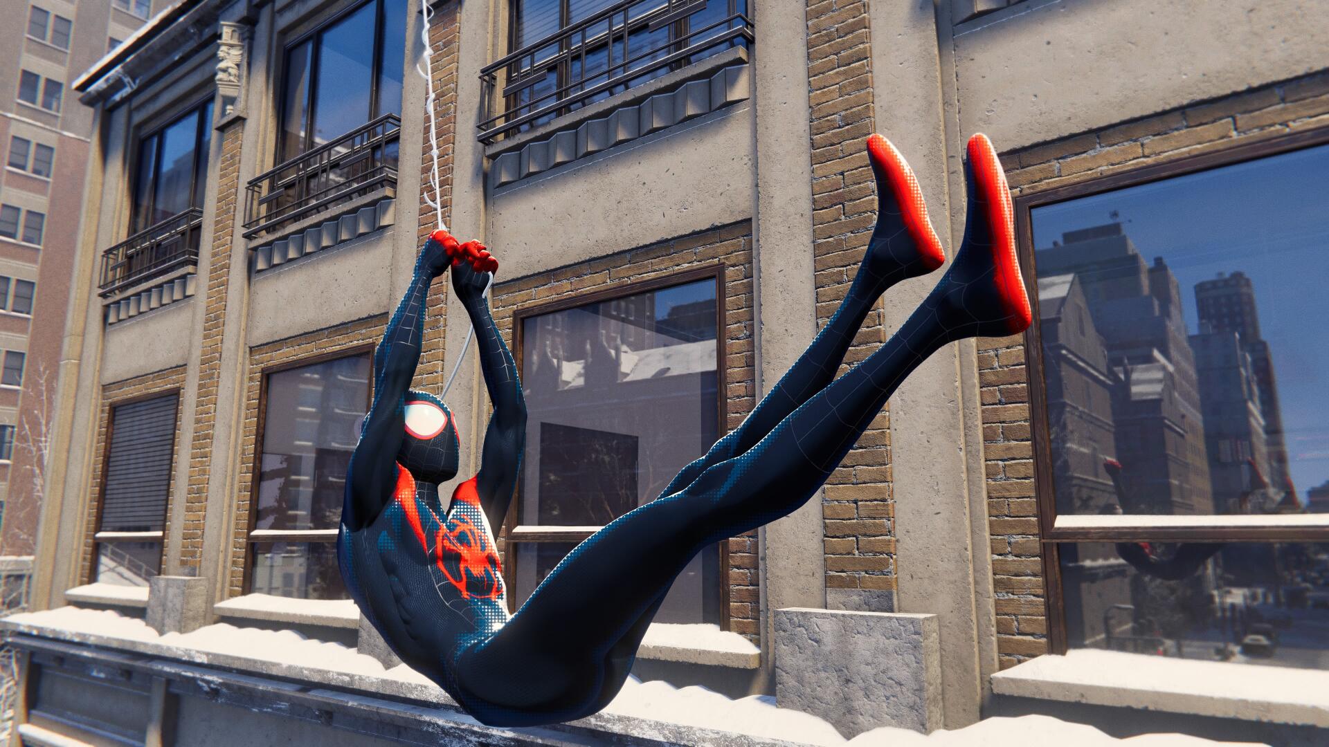 Spider-Man in a black-and-red suit swings on a web past snowy city windows — video game scene in 4K Ultra HD PC Desktop Wallpaper and Background.