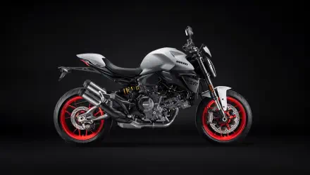 Side profile of a silver Ducati Monster motorcycle with red rims on a dark backdrop, 5K Ultra HD PC desktop wallpaper/background.