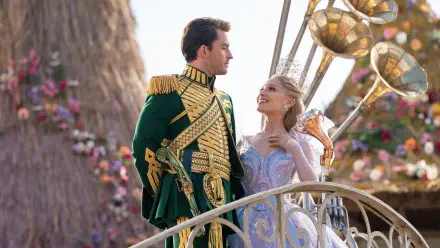 4K Ultra HD PC desktop wallpaper from Wicked: For Good — Prince Fiyero in ornate green uniform gazes at his partner in a pastel ballgown on a decorative balcony, romantic film still.