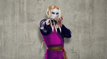 Street Fighter (2026) 2K Quad HD PC desktop wallpaper: masked fighter in purple outfit with long clawed gauntlet posing against a textured concrete wall.