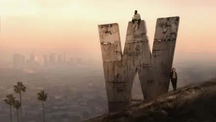 Wonder Man (2026) 4K Ultra HD PC desktop wallpaper/background: sunset haze over a sprawling city, a weathered giant 'W' monolith on a hill with two small figures nearby.