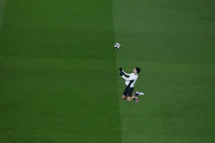 4K Ultra HD desktop wallpaper: overhead shot of a Paris Saint-Germain F.C. player leaping to head the ball during a UEFA Champions League match on a vivid green pitch.