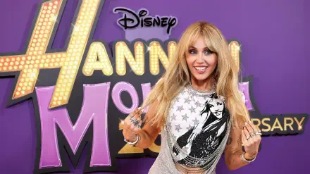 HD PC desktop wallpaper: blonde pop star posing before a large Hannah Montana TV show logo on a vibrant purple background.