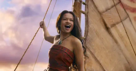 Live-action Moana movie HD PC desktop wallpaper: young woman on a sailboat, hair blowing, laughing against a warm golden sky.