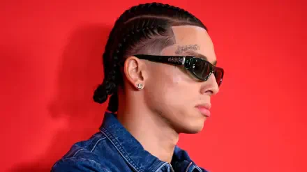 HD PC desktop wallpaper: portrait of a young British man in cornrows and sunglasses, sporting urban rap-style fashion against a vibrant red background.