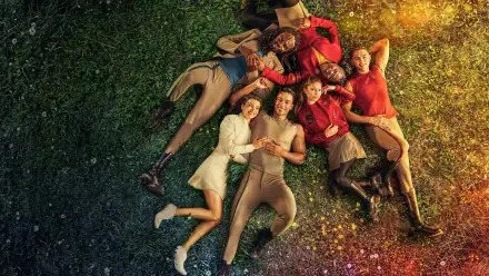 Star Trek: Starfleet Academy 2K Quad HD PC desktop wallpaper and background showing cadets in colorful uniforms lying in a circle on grass, smiling beneath warm sunlight and scattered sparkles.