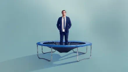 4K Ultra HD PC Desktop Wallpaper and Background: man stands on a small trampoline in a pale teal room, conveying a surreal shrinking theme.
